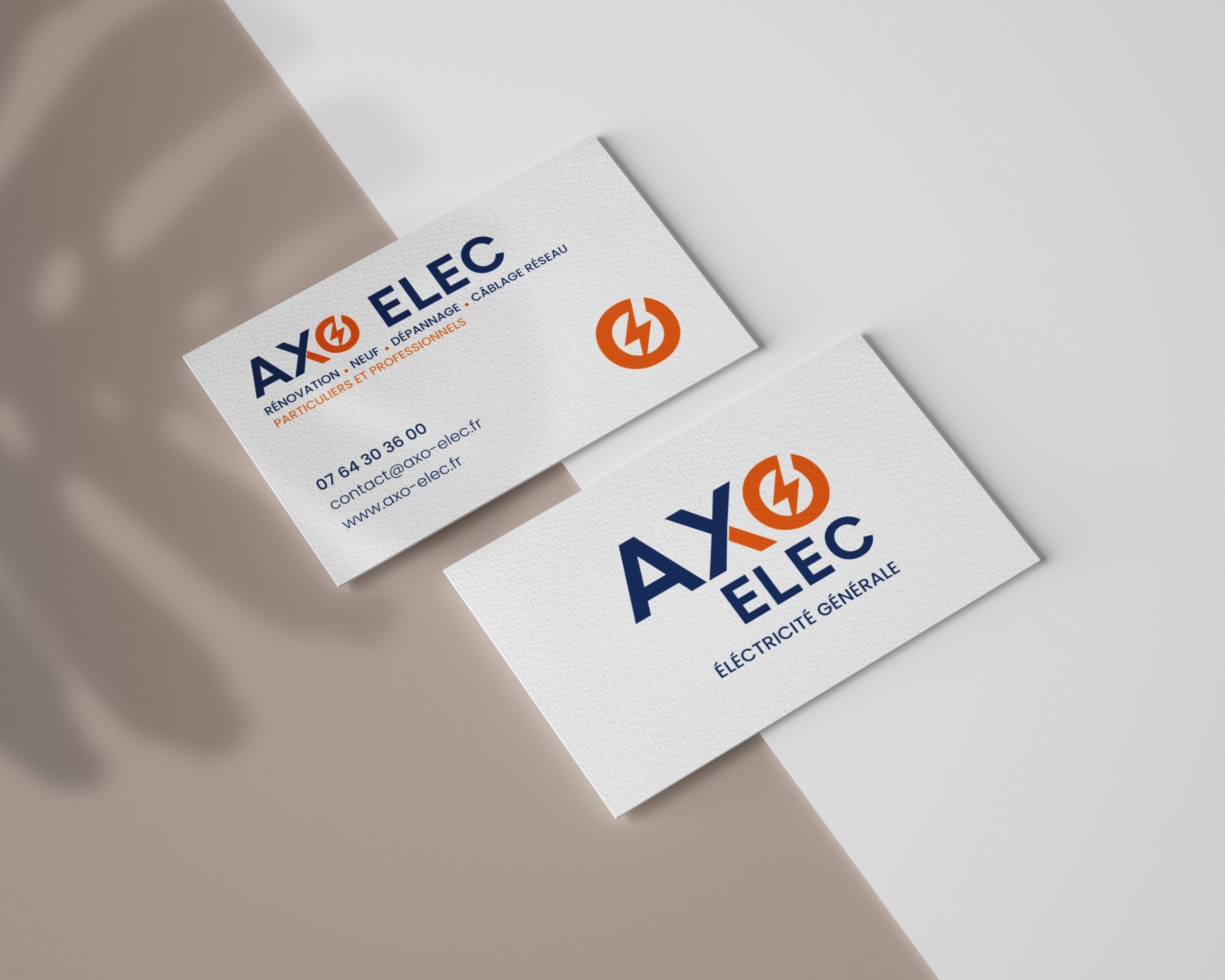 Angled white business cards featuring the blue and orange AXO ELEC logo on a textured surface.